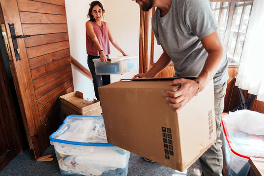 Couple Carrying Boxes While Moving In 