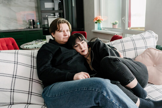 Two young women are having a cozy time on the couch.