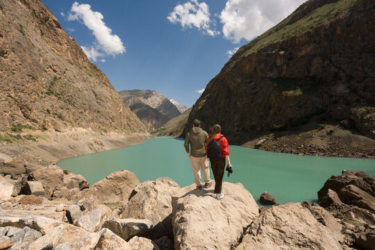 Anonymous Couple Stands on a Rock at the Lake in Tajikistan