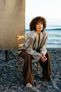 Woman with curly hair posing on beach