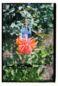 A woman stands in a wildflower meadow in a double exposure