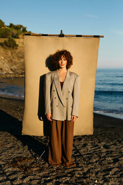 Woman posing on beach with studio backdrop