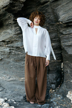 Woman posing in stylish white shirt and brown trousers