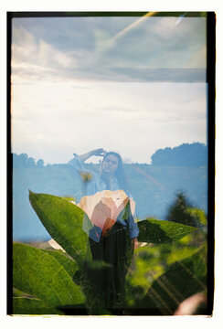 A woman dissolves into a double-exposed field and bloom