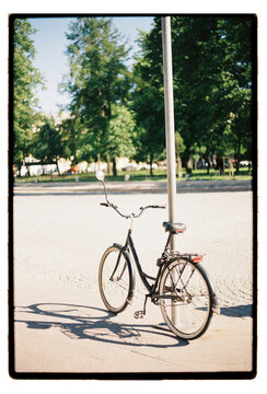 A vintage bike casts its shadow across sun-baked cobblestones