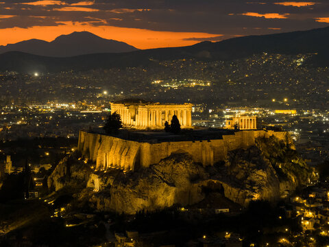 Acropolis of athens illuminated at sunset with city lights