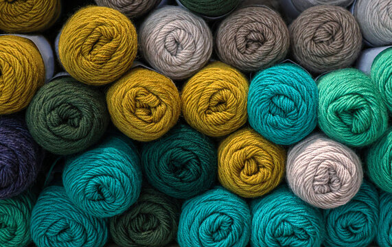 A pile of wool skeins for retail in a knitting shop.