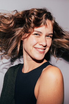 Smiling woman with flowing hair in dynamic pose