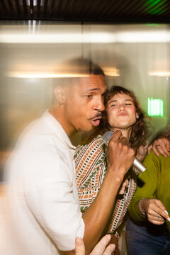 Singing karaoke with friends at a lively party