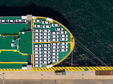 Ferry transporting many new white cars in perama port