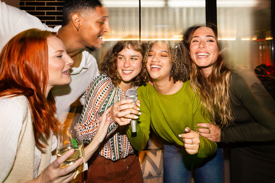 Friends enjoying karaoke at a lively social gathering