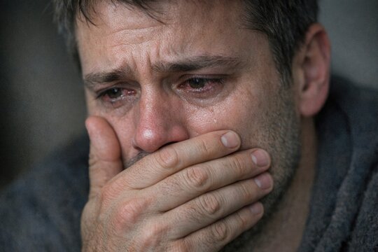 A close-up of a person hiding their face with their hand, possibly conveying embarrassment or shame