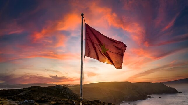 Flag of Vietnam flying on flagpole at sunset over rocky coastal landscape.