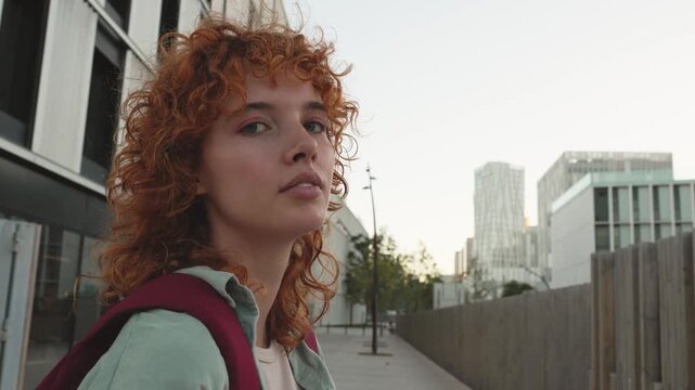 Young female student with red hair looking at camera