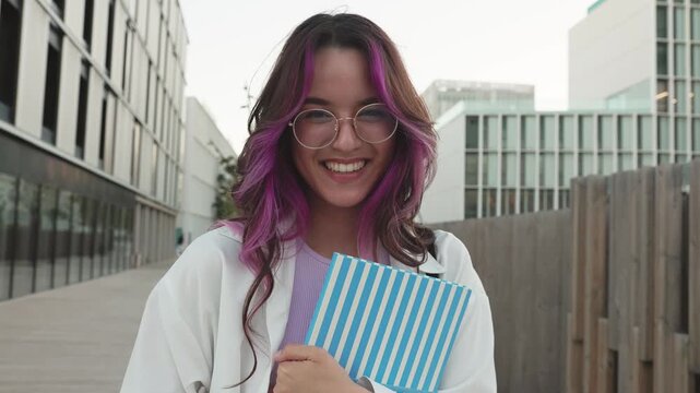 Happy university student with pink hair smiling on campus