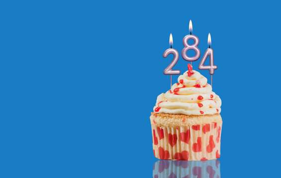 Birthday Or Anniversary Cupcake With Lit Candles; Candles Forming The Number 284