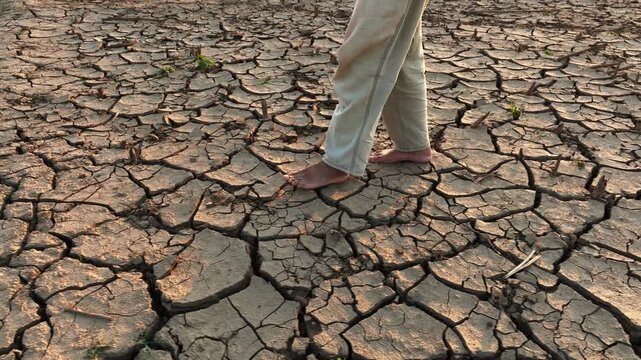 barefoot walking on cracked dry earth el nino climate impact 2026