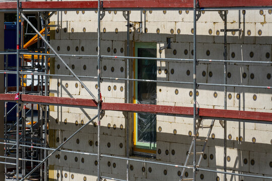 Building facade with exterior insulation system and scaffolding during energy-efficient renovation