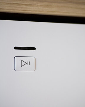 Play and Pause Button on a Modern Household Appliance Control Panel. Minimalist User Interface for Starting, Pausing, and Managing Appliance Functions.