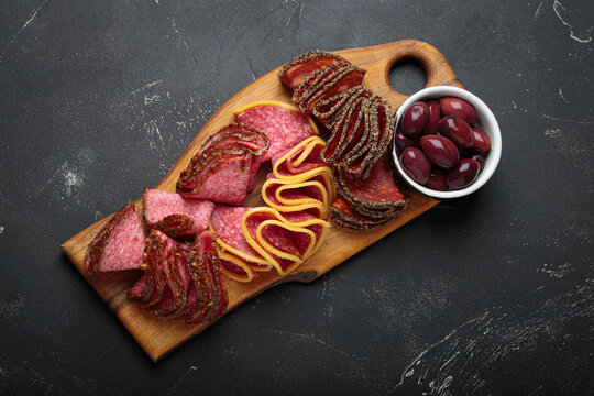 Charcuterie platter meat sliced salami pepperoni olives snack appetizer wooden board antipasto