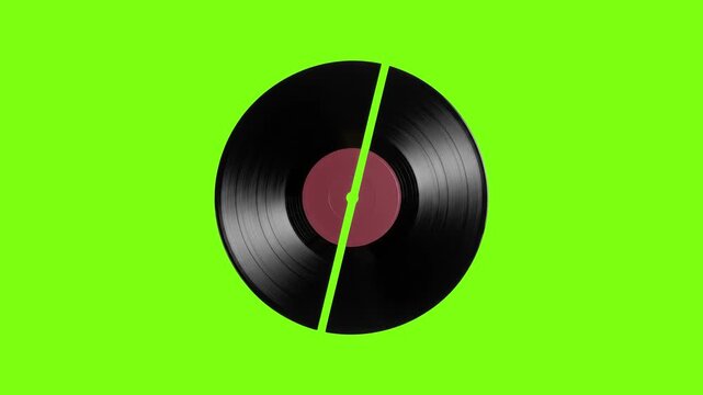 Vintage vinyl record broken in half on green screen, cracked black music disc with red label, shattered analog audio plate for video editing