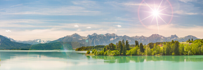 Im Allgäu spiegeln sich die Berge auf der Wasseroberfläche des Forggensee bei Füssen - FOTOMONTAGE © Wolfilser