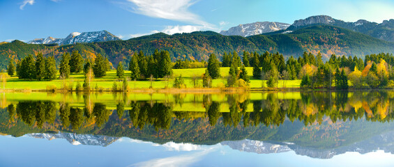 Im beginnenden Herbst spiegeln sich im Allgäu die Berge auf der Wasseroberfläche des Hegratsrieder Weiher © Wolfilser