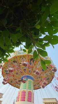 Visitors of the amusement park are enjoying the wave swinger ride. Visitors are excited to try the swing ride at the amusement park