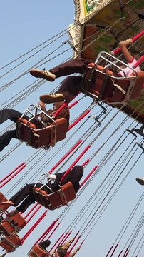 Visitors of the amusement park are enjoying the wave swinger ride. Visitors are excited to try the swing ride at the amusement park