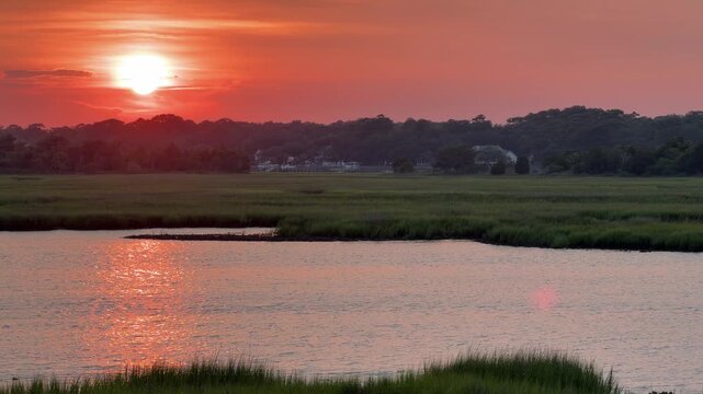 Establishing shot of a gorgeous sunset across an inlet at the beach with copy space