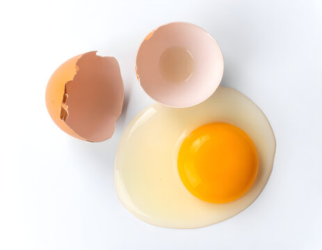 Brown egg yolk with eggshell on white background