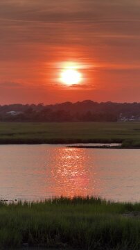 Establishing shot of a gorgeous sunset across an inlet at the beach with copy space