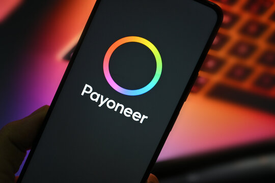 VEHARI, PAKISTAN - JULY, 22, 2026: Close up of mobile phone screen showing Payoneer application icon black screen for global money transfers and freelance payment solutions