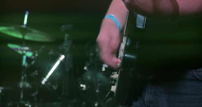 Concert stage with live rock guitar music &ndash; band perform set at entertainment festival event. Close up on instrument of electric guitarist.