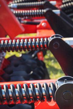 Steel black spring as part of heavy agricultural, industrial machine. Technology