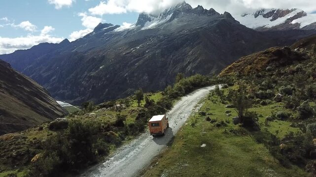 Camper car in Huascaran: high mountains with ice peak in Peru drone view 
