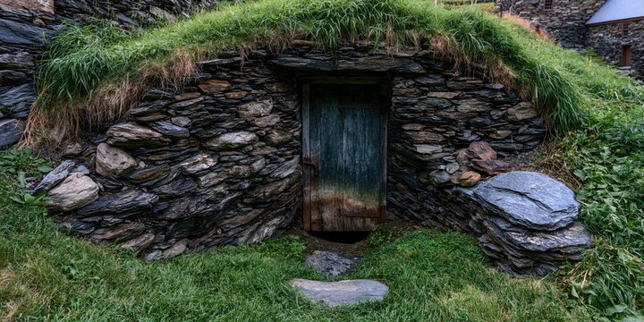 Stone House with Moss-Covered Roof and Wooden Door