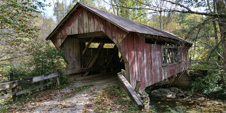 Rustic Wooden Covered Bridge Over a Stream in a Forest