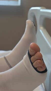 Patient Wearing White Compression Stockings in Hospital Bed