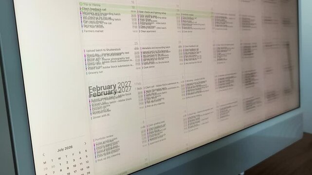 Camera panning over a colorful weekly planning board. Sticky notes organizing tasks across a physical schedule chart. Blurred motion shot of a home productivity display..