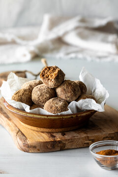 Cinnamon and protein powder dusted energy balls in a bowl.