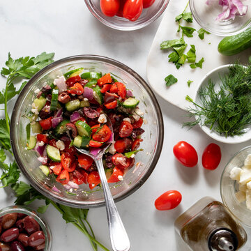 A tossed Mediterranean salad with fresh ingredients all around. 