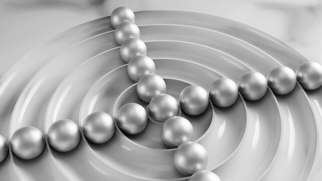 Metallic balls rolling on white concentric circles create a mesmerizing visual loop