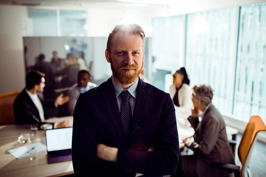 Confident business leader standing in modern office conference room