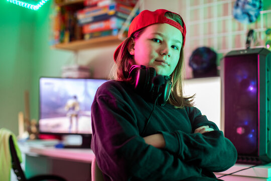 Confident teen gamer with headset in bedroom gaming setup