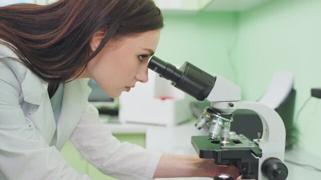 woman scientist with microscope in lab