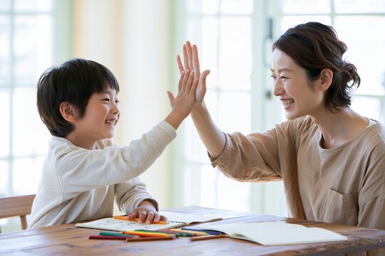 笑顔の親子がハイタッチ子供と母親の喜びと絆育児の楽しい時間