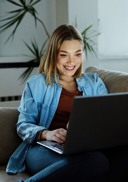 Portrait of young happy woman using laptop at night, using modern technology having fun with glowing screen in dark office or at home, startup business meeting online with businesswoman  in the office