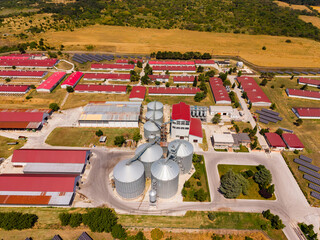 Farm complex with grain silos and storage buildings seen from above in rural area during daytime © DSMT