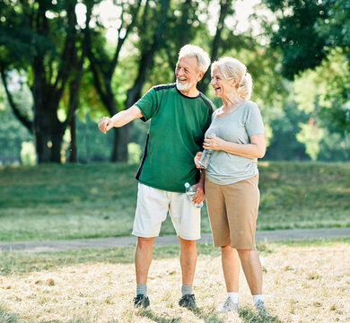 Smiling active senior couple jogging together in the park